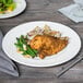 A Libbey porcelain plate with chicken and green beans on a table.