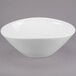 A white Libbey porcelain bowl with a curved edge on a gray background.