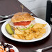 A Libbey white porcelain plate with a sandwich and chips on it.