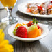 A Libbey Royal Rideau white porcelain bowl filled with fruit on a table.