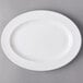 A white oval Libbey porcelain platter with a white rim on a gray surface.