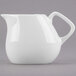 A white porcelain creamer with a handle.