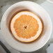 A half of an orange in a Tuxton Hampshire eggshell embossed China bowl.