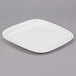 A white square Libbey porcelain plate with a small rim on a gray surface.
