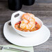 A bowl of shrimp on a Libbey Royal Rideau white porcelain saucer.