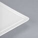 A close-up of a Libbey white porcelain square plate corner with a thin edge.