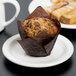 A muffin on a Libbey round white porcelain plate with a narrow rim.