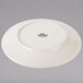 A white Tuxton china plate with black embossed text and a black rim.