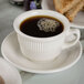 A Tuxton Hampshire eggshell short cup filled with coffee on a plate of toast.