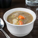 A white Libbey porcelain bouillon bowl filled with soup and vegetables.