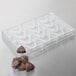 A clear plastic tray with chocolate in it shaped like triangles.