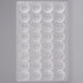 A white Chocolate World plastic tray with 32 round compartments.