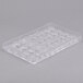 A clear plastic tray with round and variously shaped compartments.