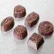 A Matfer Bourgeat polycarbonate chocolate candy mold with 36 designs including flowers, leaves, and swirls.