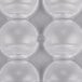 A close-up of a clear plastic Matfer Bourgeat chocolate mold with half circle compartments.