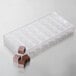 A clear plastic Chocolate World square mold with 32 compartments for chocolate pieces.
