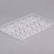 A clear plastic tray with 32 half spheres.