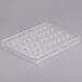 A clear plastic tray with many small rectangular holes.