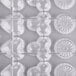 A clear plastic Matfer Bourgeat chocolate mold tray with hexagon and heart shaped compartments.