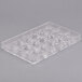 A clear plastic mold with various shapes including small balls.