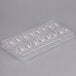 A clear plastic Chocolate World quenelle mold with 16 compartments.