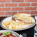 An oval platter with a sandwich and chips on a table.