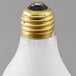 A close up of a Satco frosted incandescent light bulb with a gold tip.