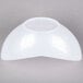 A white plastic bowl on a gray surface.