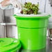 A person in a white coat and gloves using a Choice Prep salad spinner to dry lettuce.