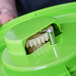 A white plastic gear inside a green plastic salad spinner.