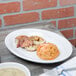 A Fiesta white china oval platter holding food on a table.