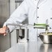 A chef using a Nemco manual vegetable cutter to make vegetable pasta.