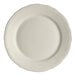 An ivory-colored, round plate with a scalloped edge.