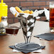 Clipper Mill metal mini square cone basket filled with chicken nuggets on a table in a fast food restaurant.