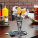 A Clipper Mill metal cone basket with chicken nuggets in it on a table.