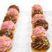 A row of InnoPak cupcake containers filled with cupcakes with chocolate and pink frosting and sprinkles.