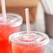 A close-up of a plastic cup with a red and white striped straw in it.