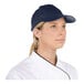 A woman wearing a navy 6-panel cap.