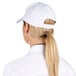 A woman wearing a white Choice 6-panel cap with a ponytail.