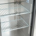 A black Avantco back bar refrigerator with shelves.