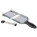 A Mercer Culinary dual thickness hand slicer on a cutting board with a knife.