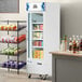 An Avantco white glass door merchandiser freezer with a shelf full of food.