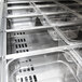 A Turbo Air stainless steel refrigerated sandwich prep table with trays of food inside.