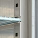 A metal shelf with blue handles inside an Avantco stainless steel reach-in refrigerator.