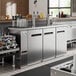 An Avantco stainless steel double tap kegerator in a bar.