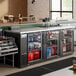 An Avantco black counter height back bar refrigerator with glass doors filled with drinks and bottles.