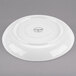 A white Libbey porcelain saucer with a circular design on it.