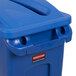 A blue Rubbermaid Slim Jim recycling container with a blue slotted lid.