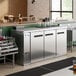 An Avantco stainless steel back bar refrigerator with bottles inside.
