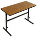 A brown rectangular table with black metal legs and a black frame.